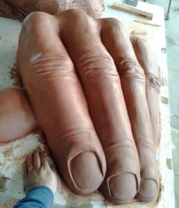 Escultura realista que reproduce una mano gigante